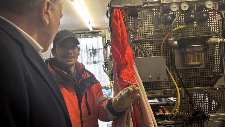 Wethouder de Kloet kijkt in de bus met apparatuur