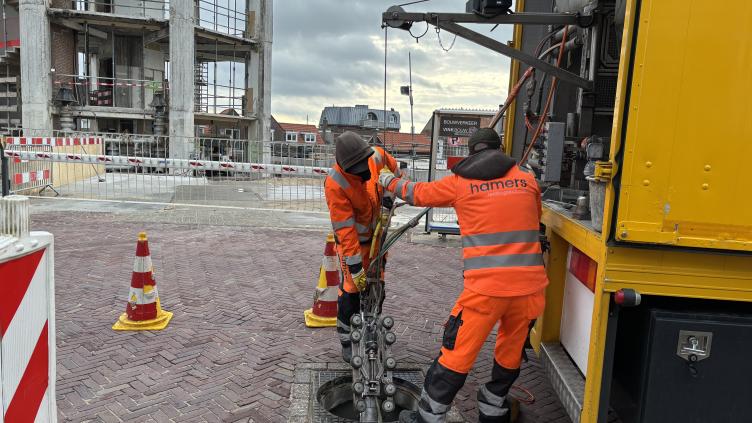 Medewerkers van Heijmans laten de robot in het riool zakken