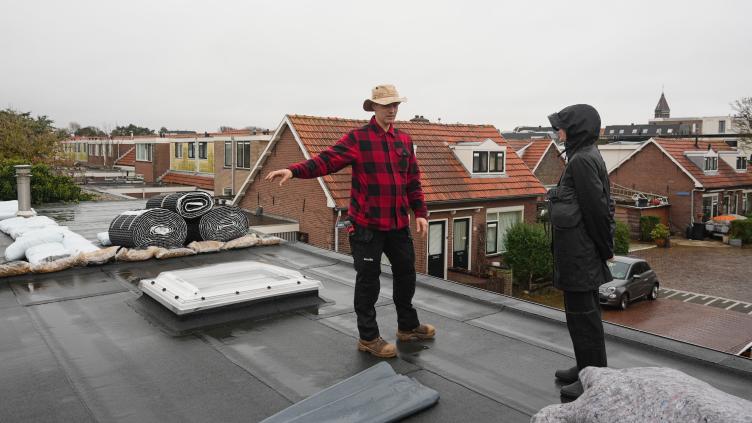 Buurtbewoners op het dak tijdens het aanleggen van hun groene dak