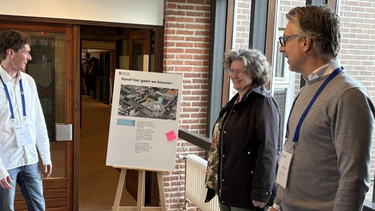 Aanwezigen bij het bord 'vanaf hier wordt gebouwd'