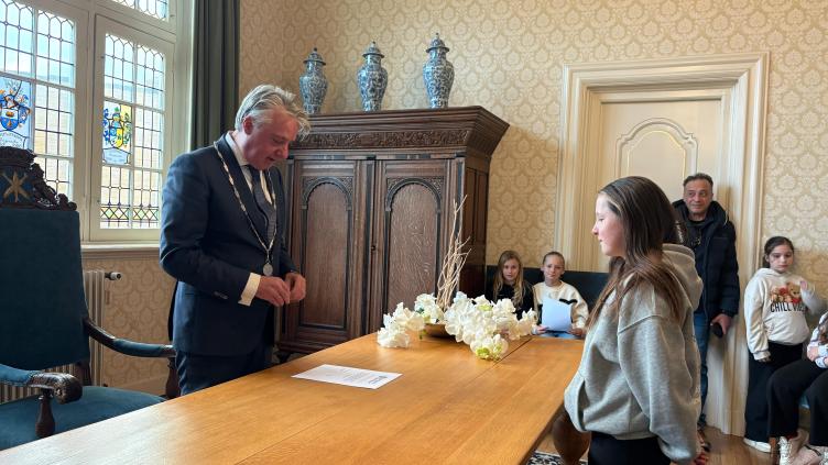 Burgemeester Moolenburgh neemt de eed af bij een lid van de kindercommissie