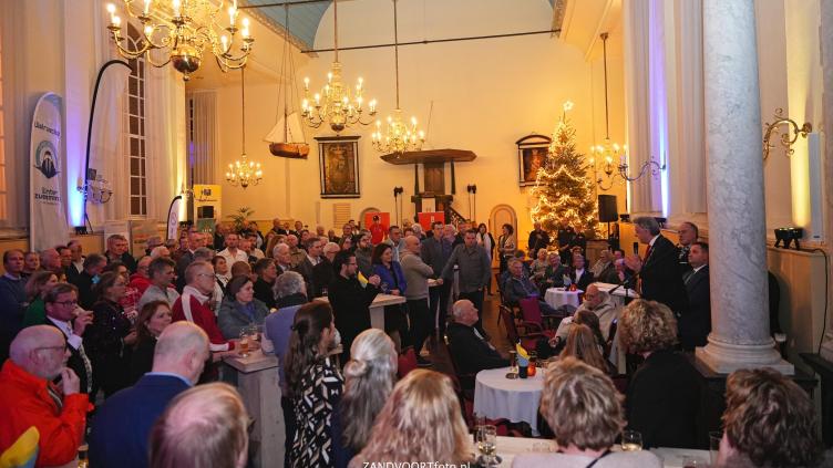 Een groep mensen in de dorpskerk voor de nieuwjaarstoespraak