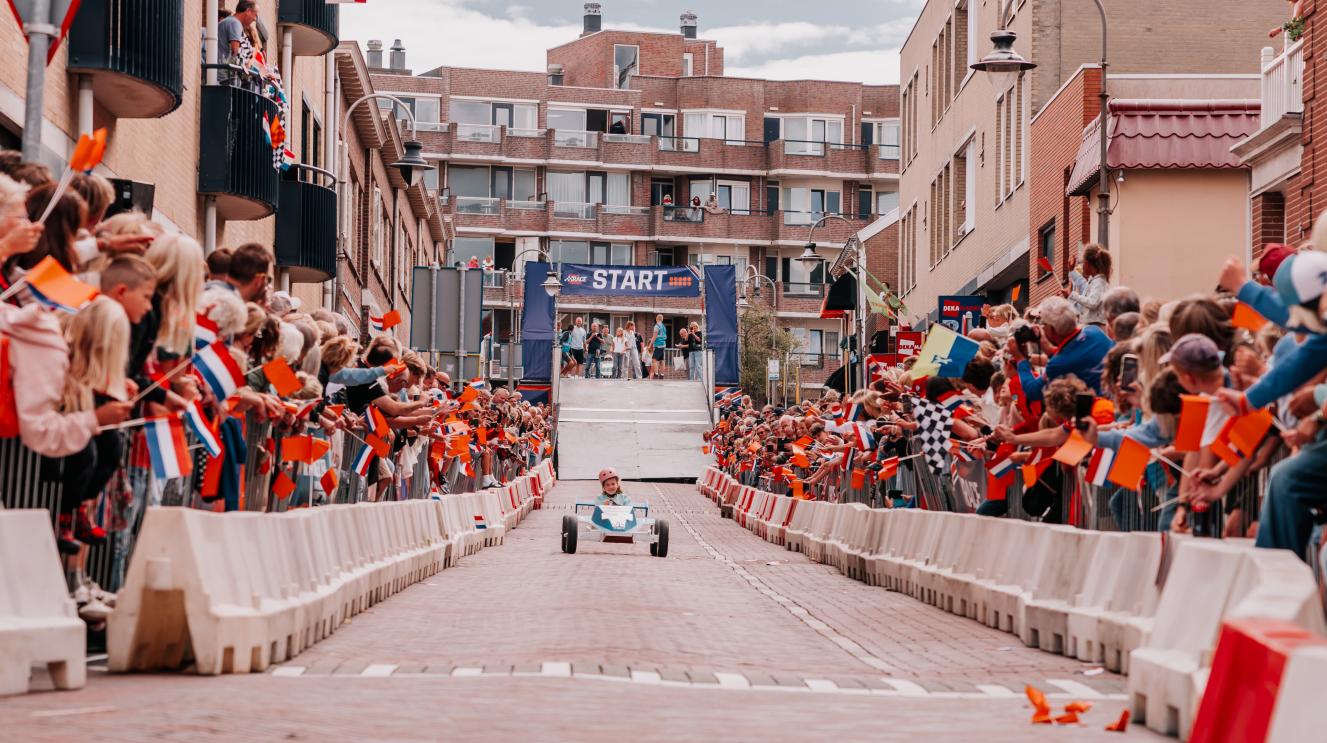 Zeepkist rijdt de Oranjestraat af tijdens de zeepkistenrace