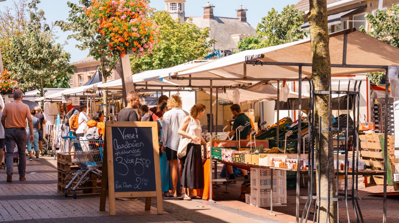 Mensen bij marktkraampjes in de herfstzon in Zandvoort