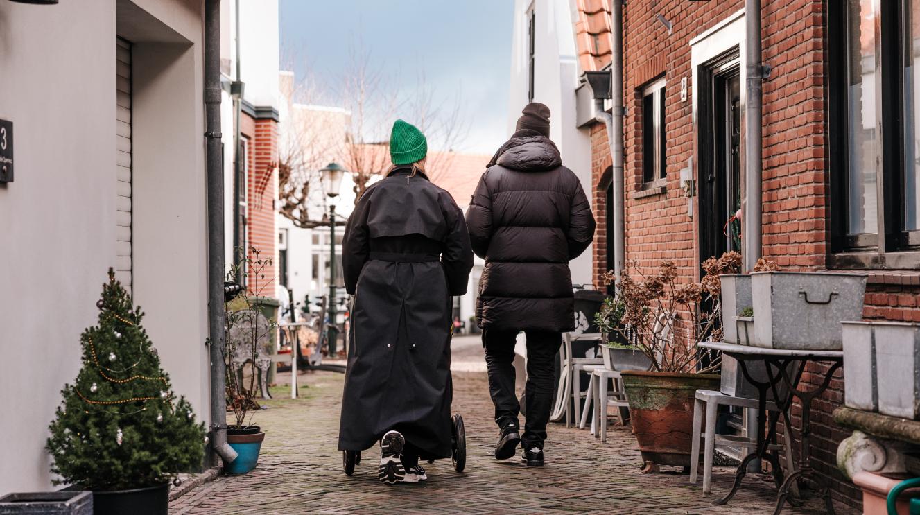 Wandelend stel met kinderwagen in een straat in het centrum