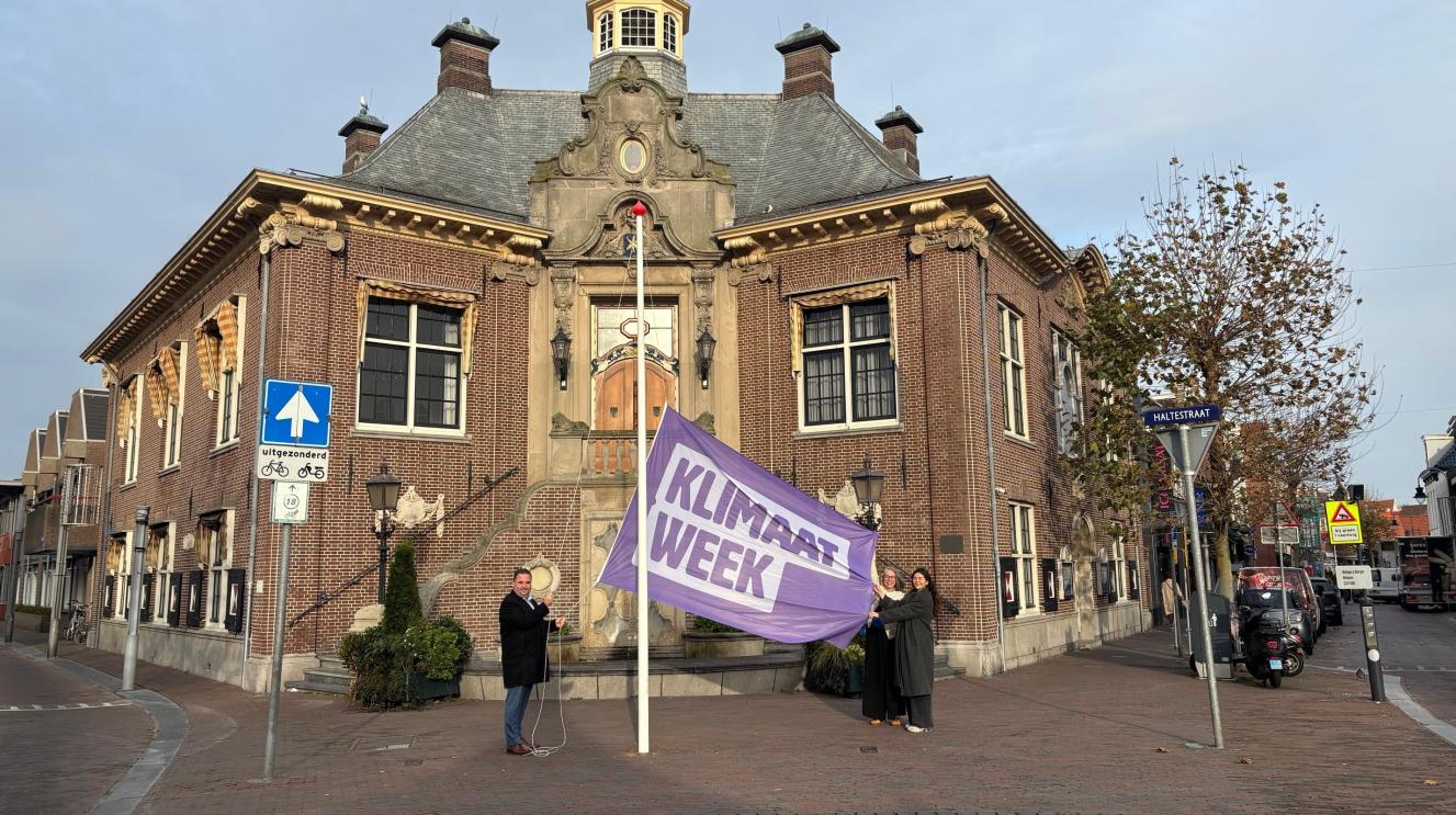 De vlag van Klimaatweek wordt gehesen voor het raadhuis