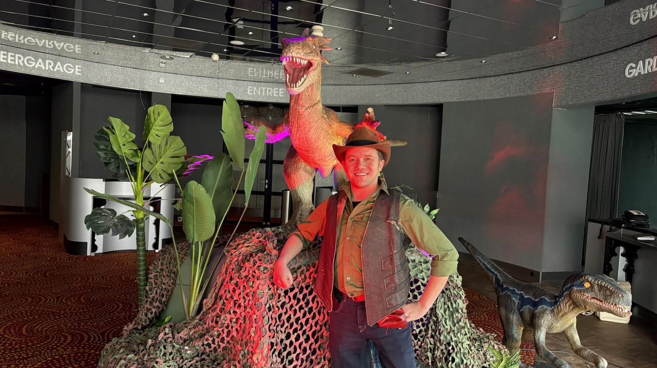 Een ranger van World of Dino's poseert voor dino's