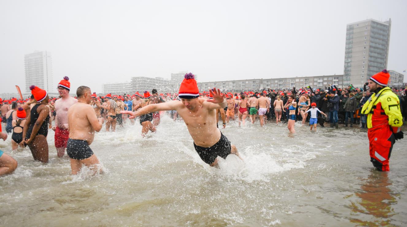 Mensen duiken tijdens de nieuwjaarsduik de zee in