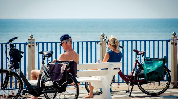Twee mensen op een bankje bij het strand